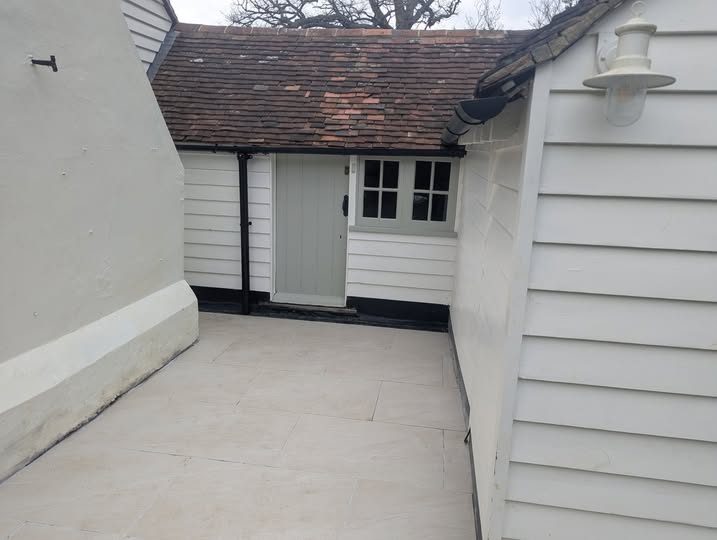 Repaved courtyard between white weatherboard cottages