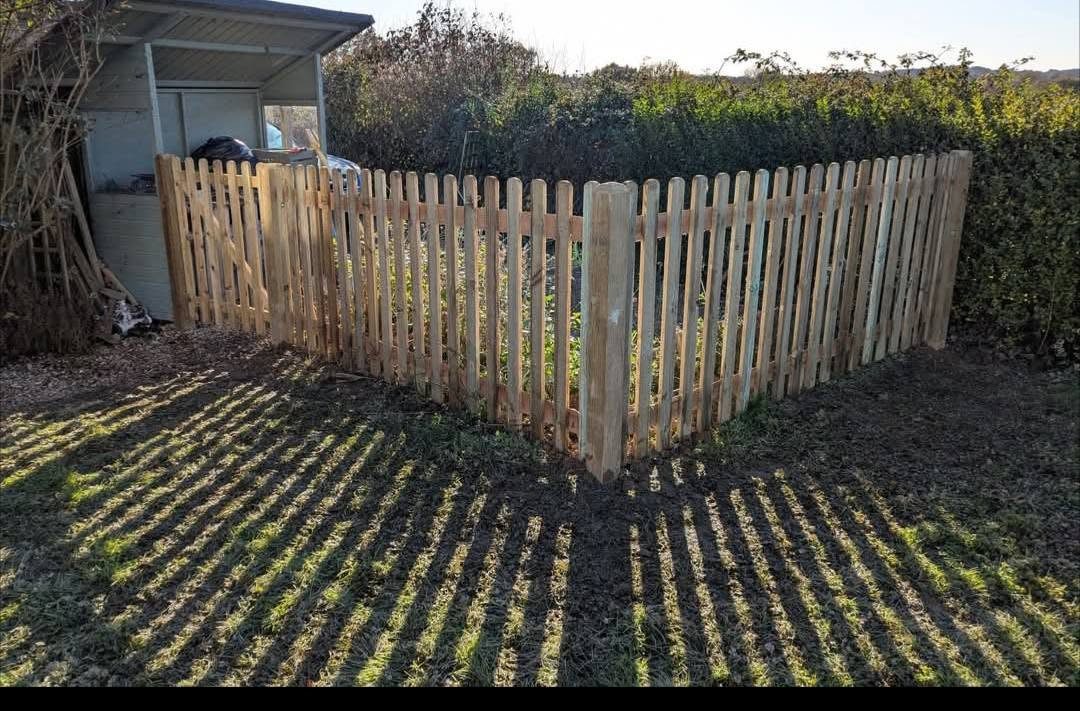 Picket fence around a kitchen garden corner in low sun