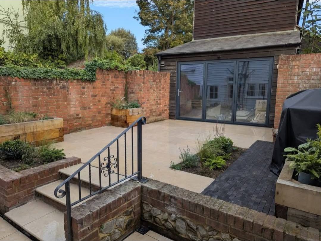 Finished walled garden with bifold doors and black clay paver path