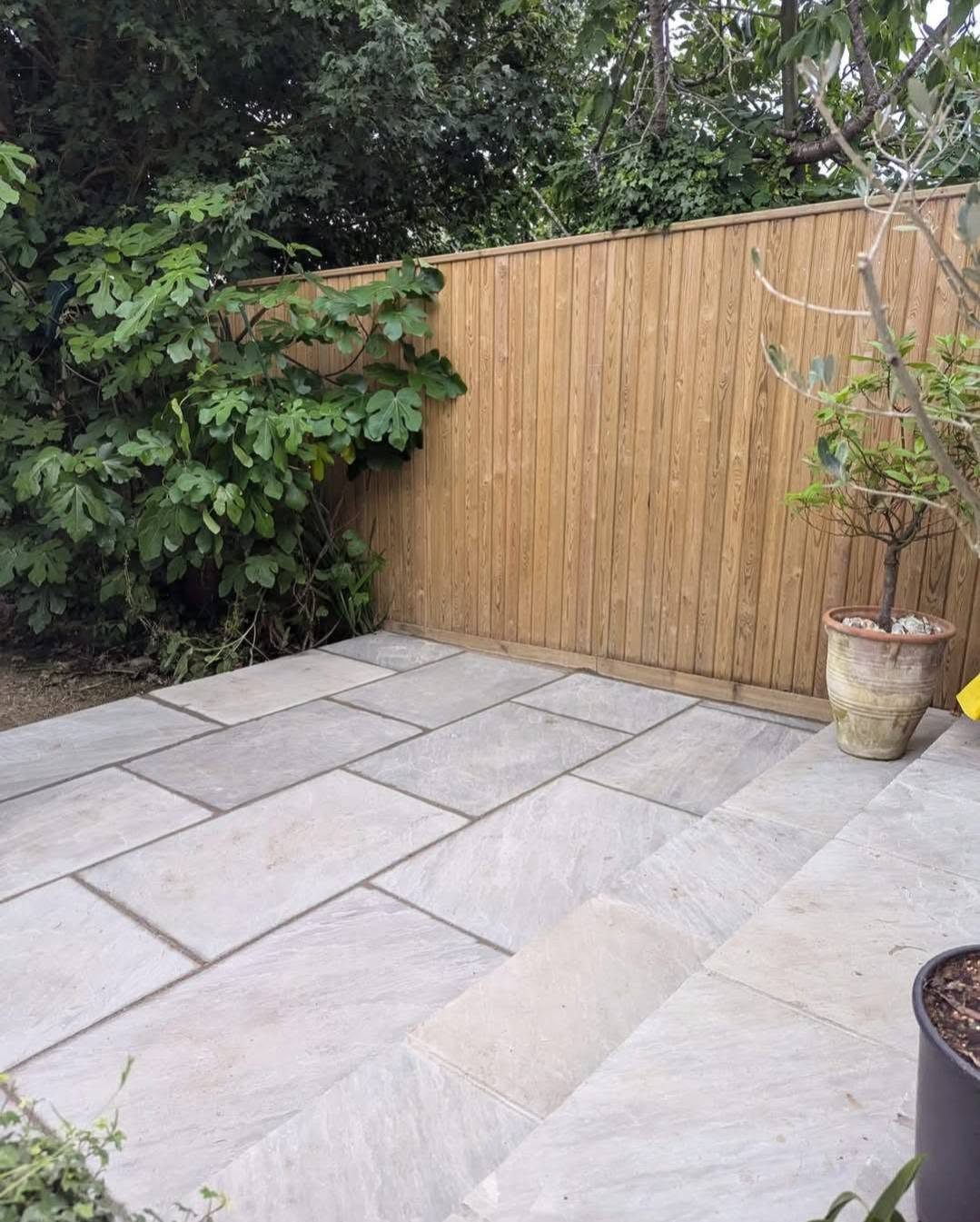 Grey sandstone paving and steps beside a new timber fence